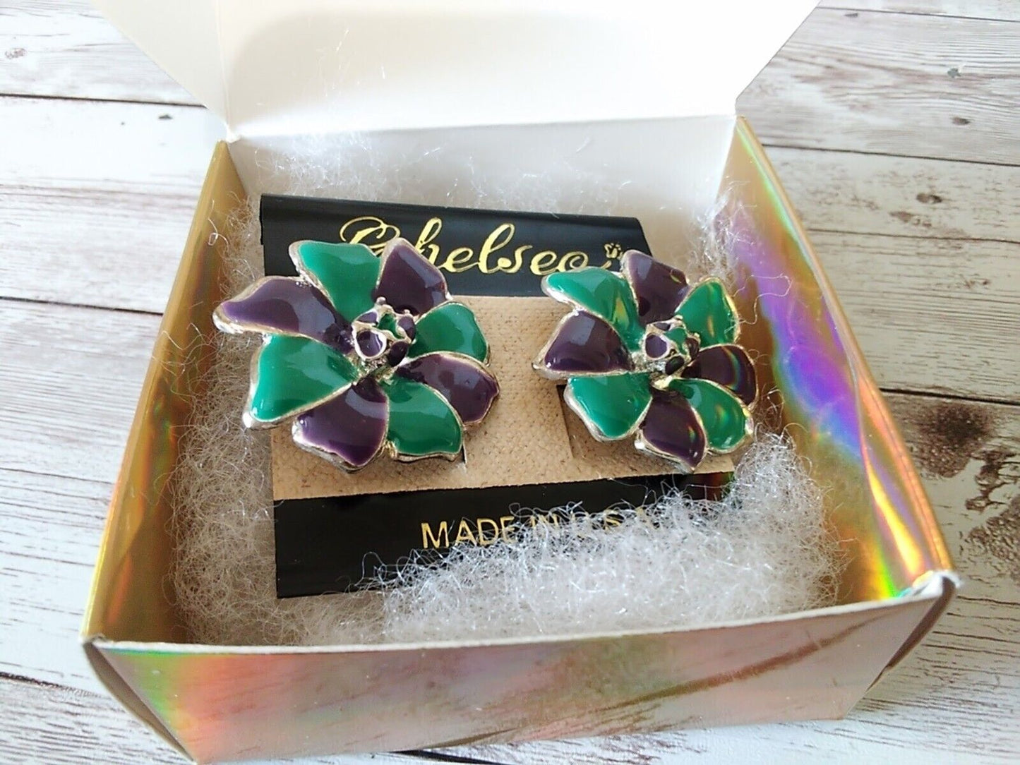 Purple and teal earrings on their original card in gift box
