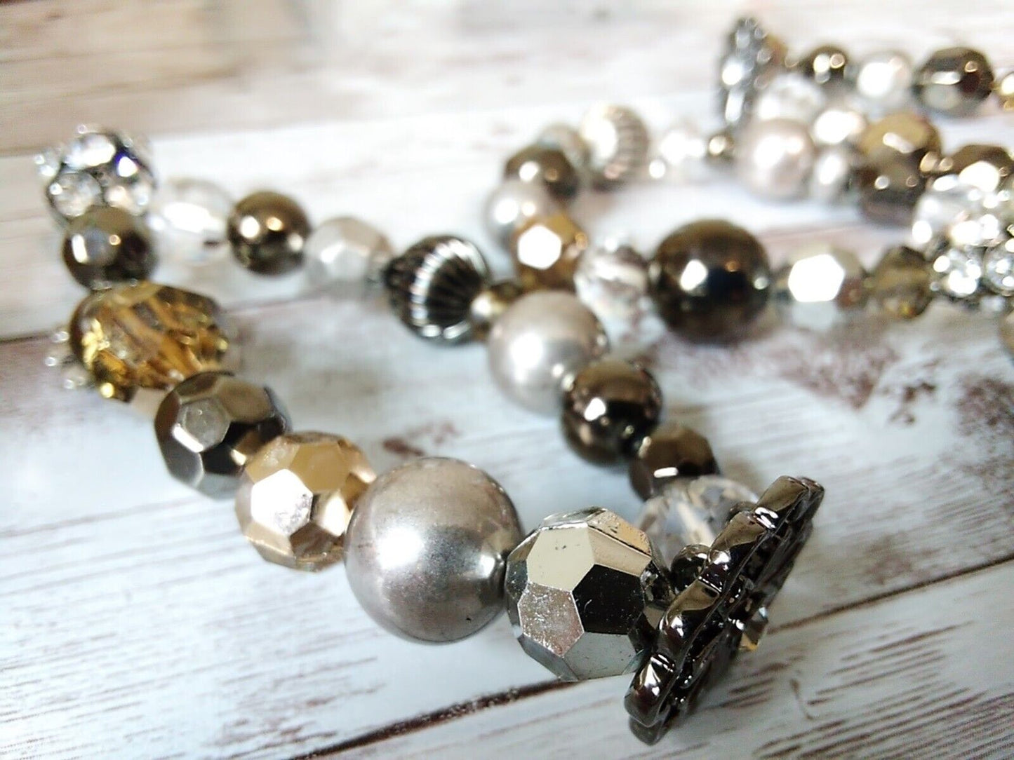 Close-up of silver, gray, and champagne beaded bracelet trio