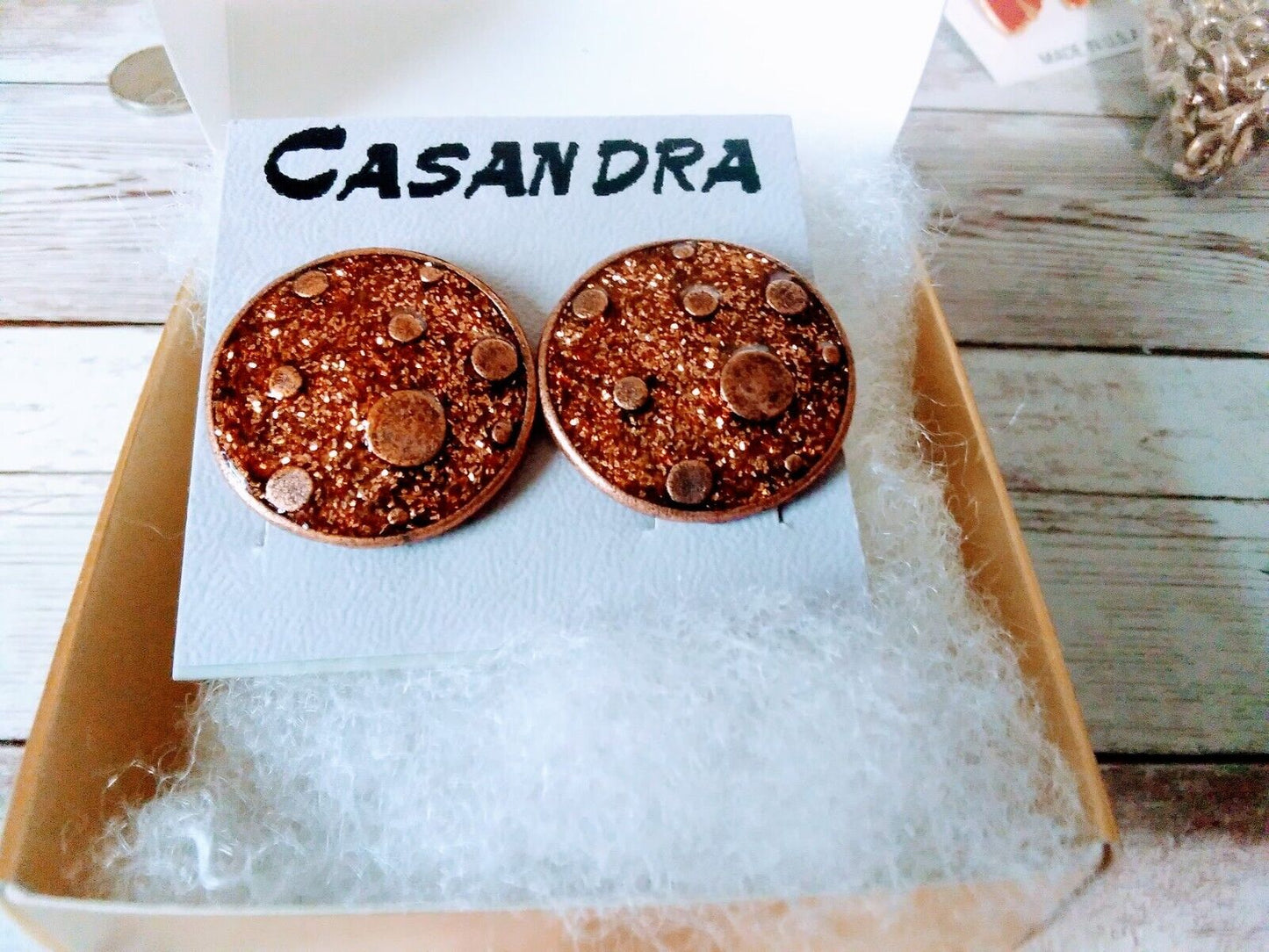 Close-up of Copper Planet Delight 80s Earrings in gold gift box