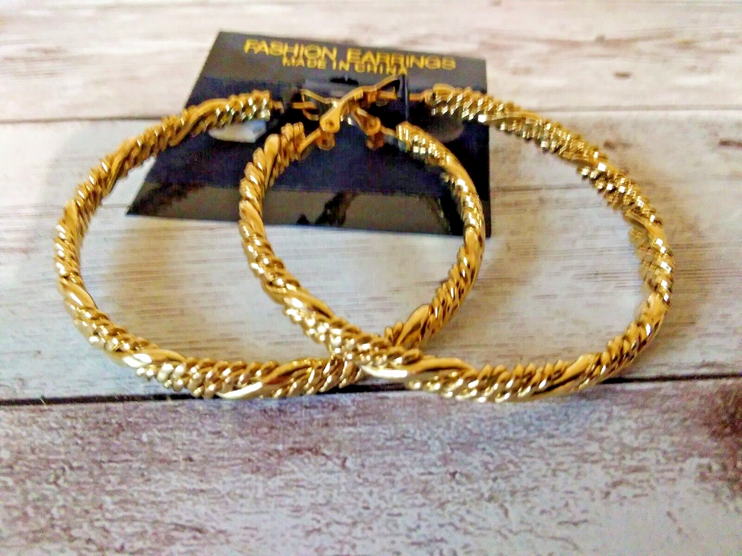Shiny gold-plated earrings featuring twisted rope motif