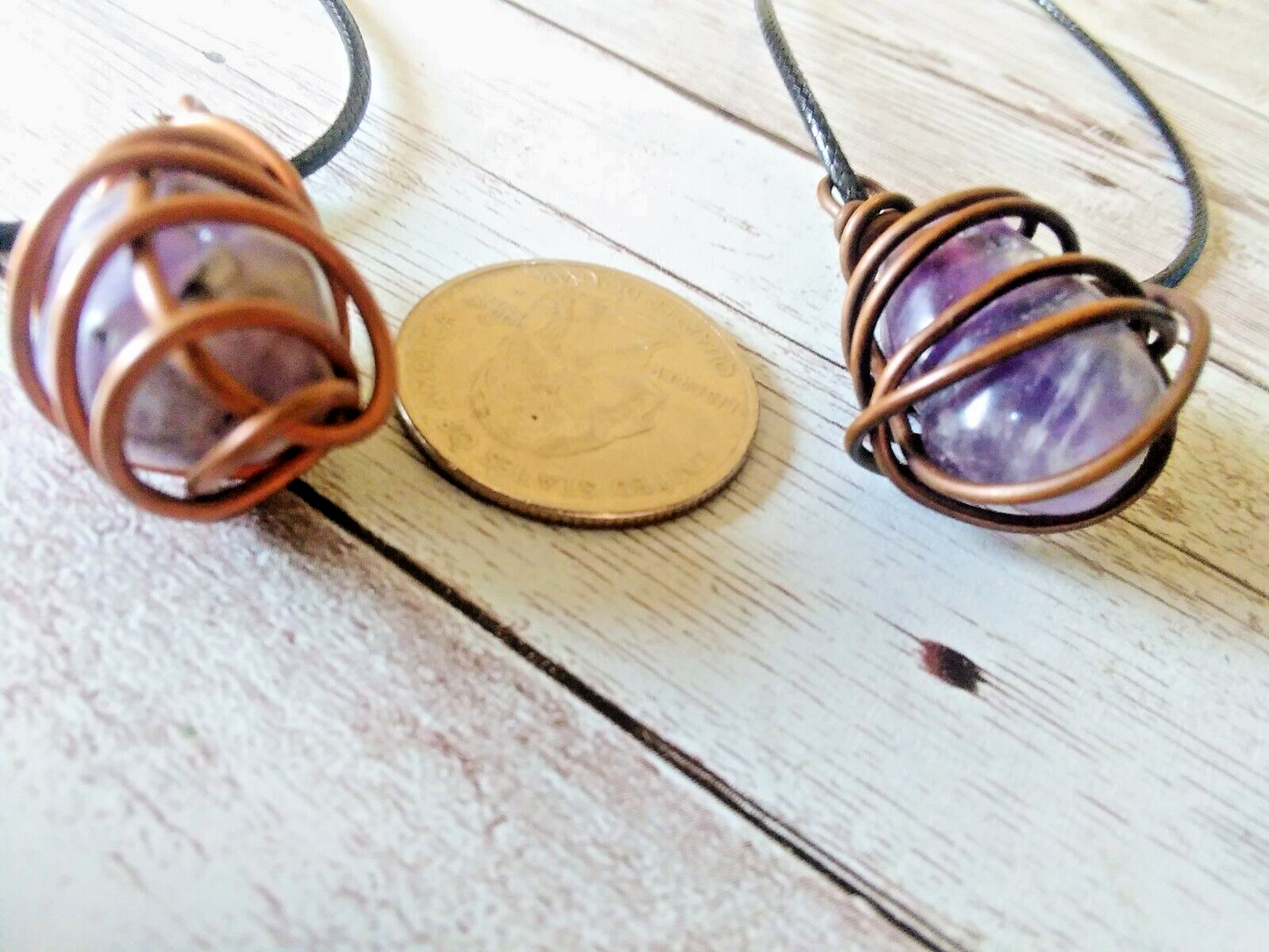 Display of Copper Wrapped Raw Amethyst Necklaces with varying purple hues and patterns next to American quarter