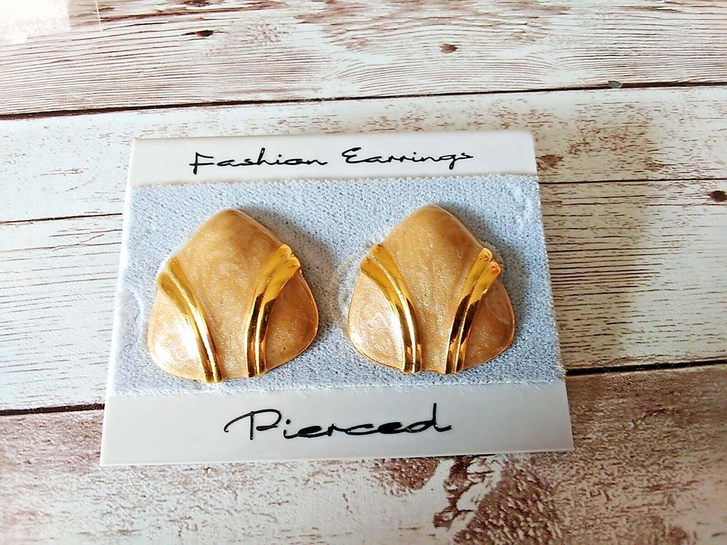 Close-up of tan and gold plated round triangle earrings