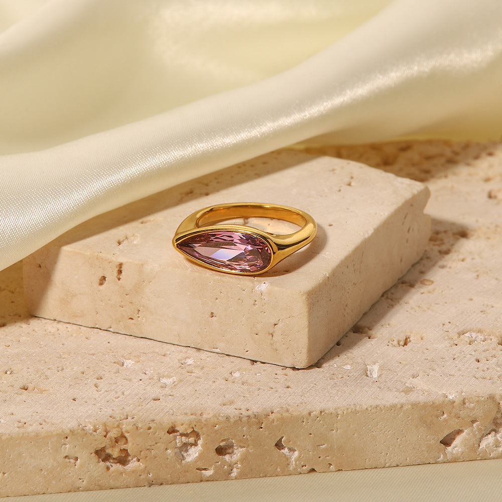 Close-up of the gold band and oval pink cubic zirconia in the ring