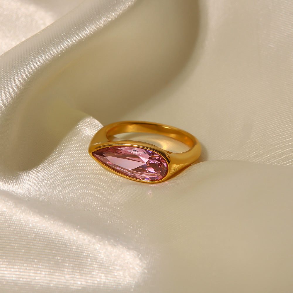 Elegant 18K gold ring with pink cubic zirconia on a display stand