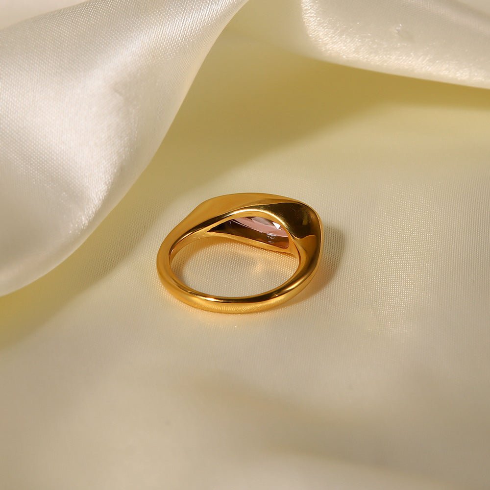 Back view of 18K gold ring with a smooth band and pink cubic zirconia