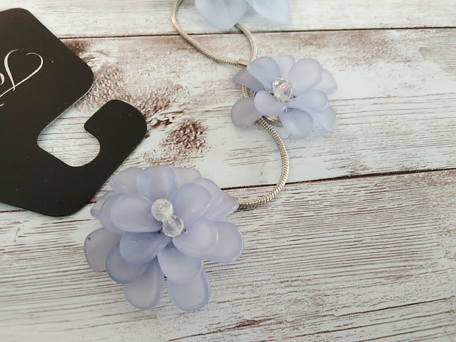 Close-up of lavender purple flower on silver bolo necklace