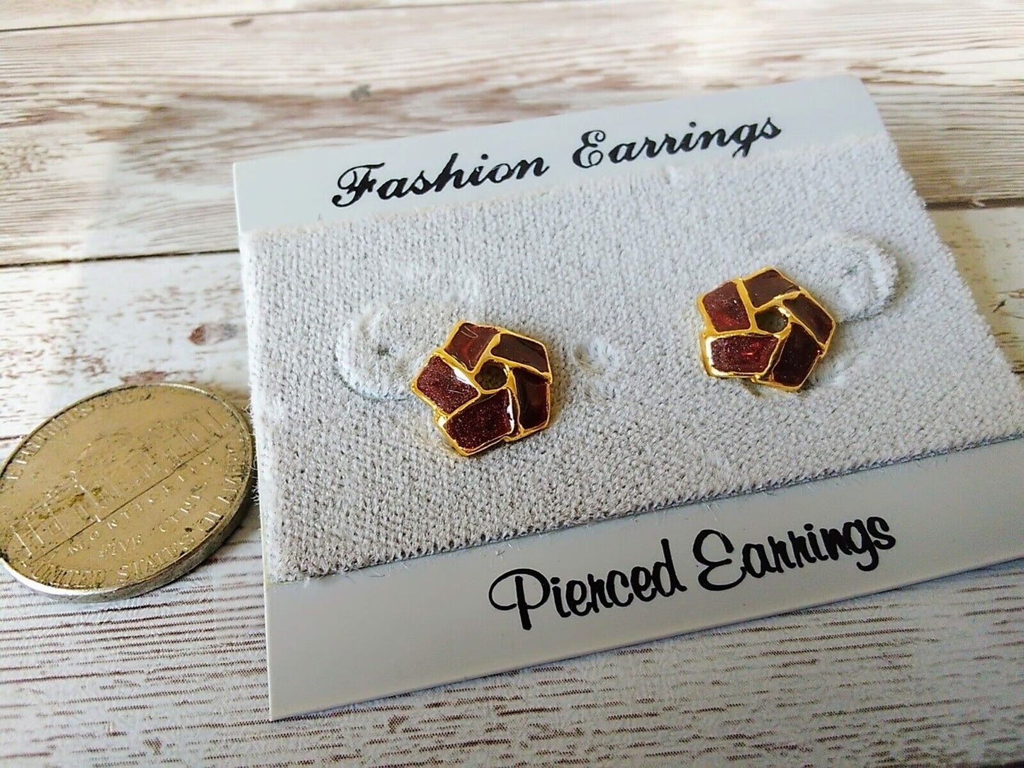 Gold-plated geometric stud earrings with vibrant burgundy color. They are smaller than the size of a nickel.