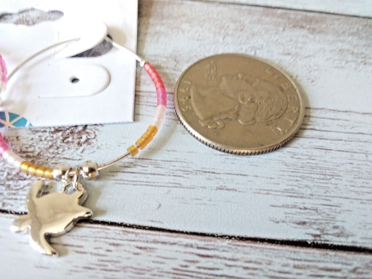 Close-up of Colorful Beadwork on Turtle Hoop Earrings and a Quarter to measure the size