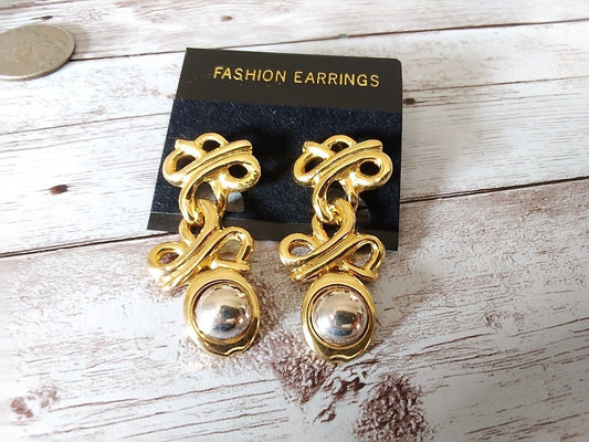 Gold and silver tone ornamental drop earrings close-up